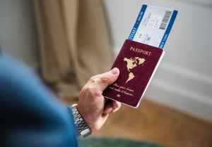 selective focus photography of person holding passport with ticket